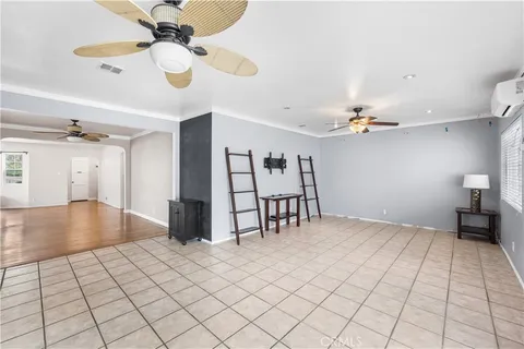 a view of an empty room and chandelier fan