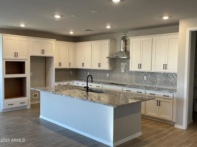 a kitchen with kitchen island granite countertop a sink stove and refrigerator
