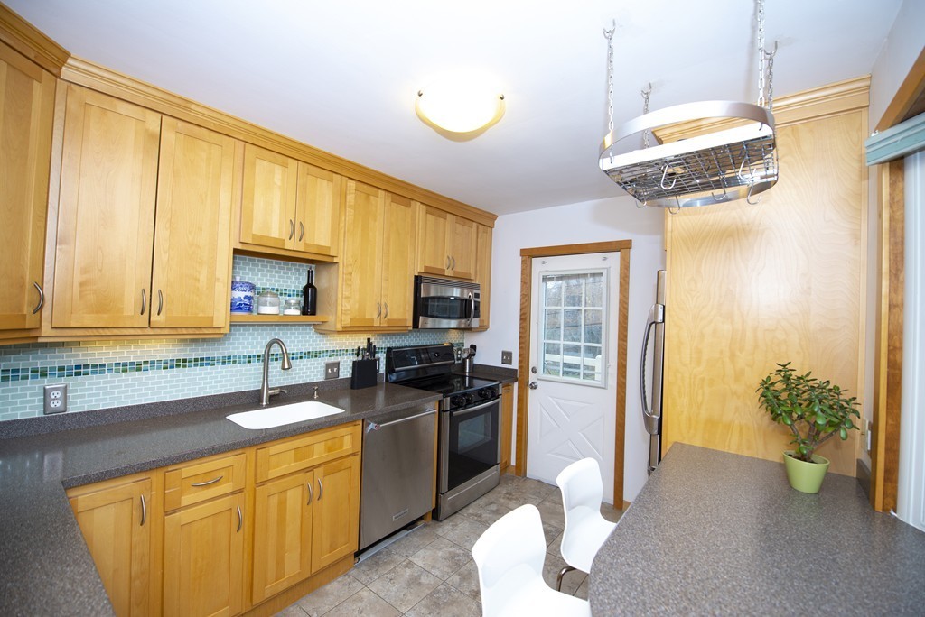 63 Pine Street Natick, MA 01760 - Photo 4 of 19 a kitchen with stainless steel appliances granite countertop a sink a stove and a refrigerator