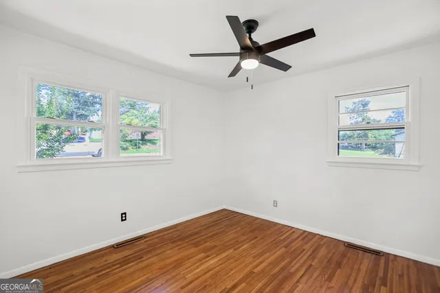 a view of a livingroom with wooden floor and a ceiling fan