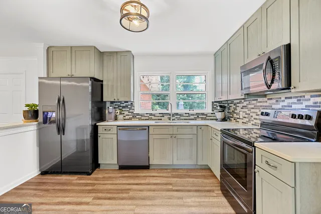 a kitchen with stainless steel appliances granite countertop a stove a sink and a refrigerator