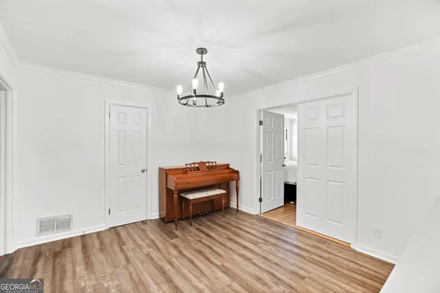 a bedroom with a bed and a flat tv screen on dresser