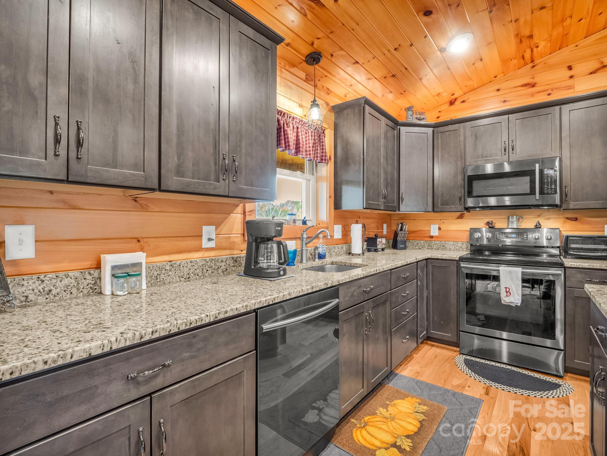 653 Moonlight Pass Union Mills, NC 28167 - Photo 11 of 44 a kitchen with stainless steel appliances granite countertop wooden cabinets a sink and dishwasher
