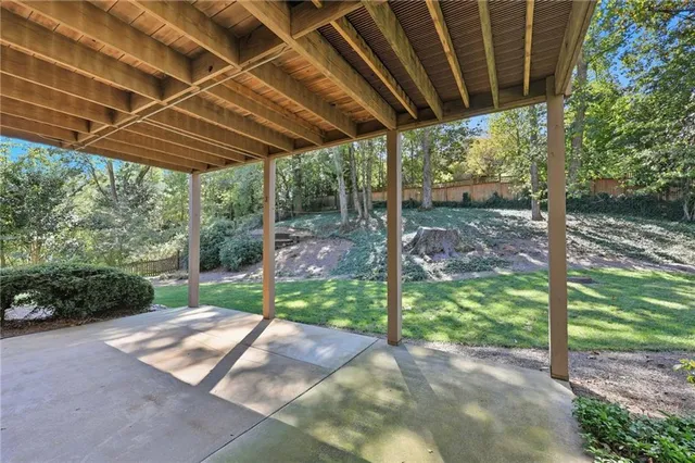 a view of a backyard with table and chairs under a large umbrella