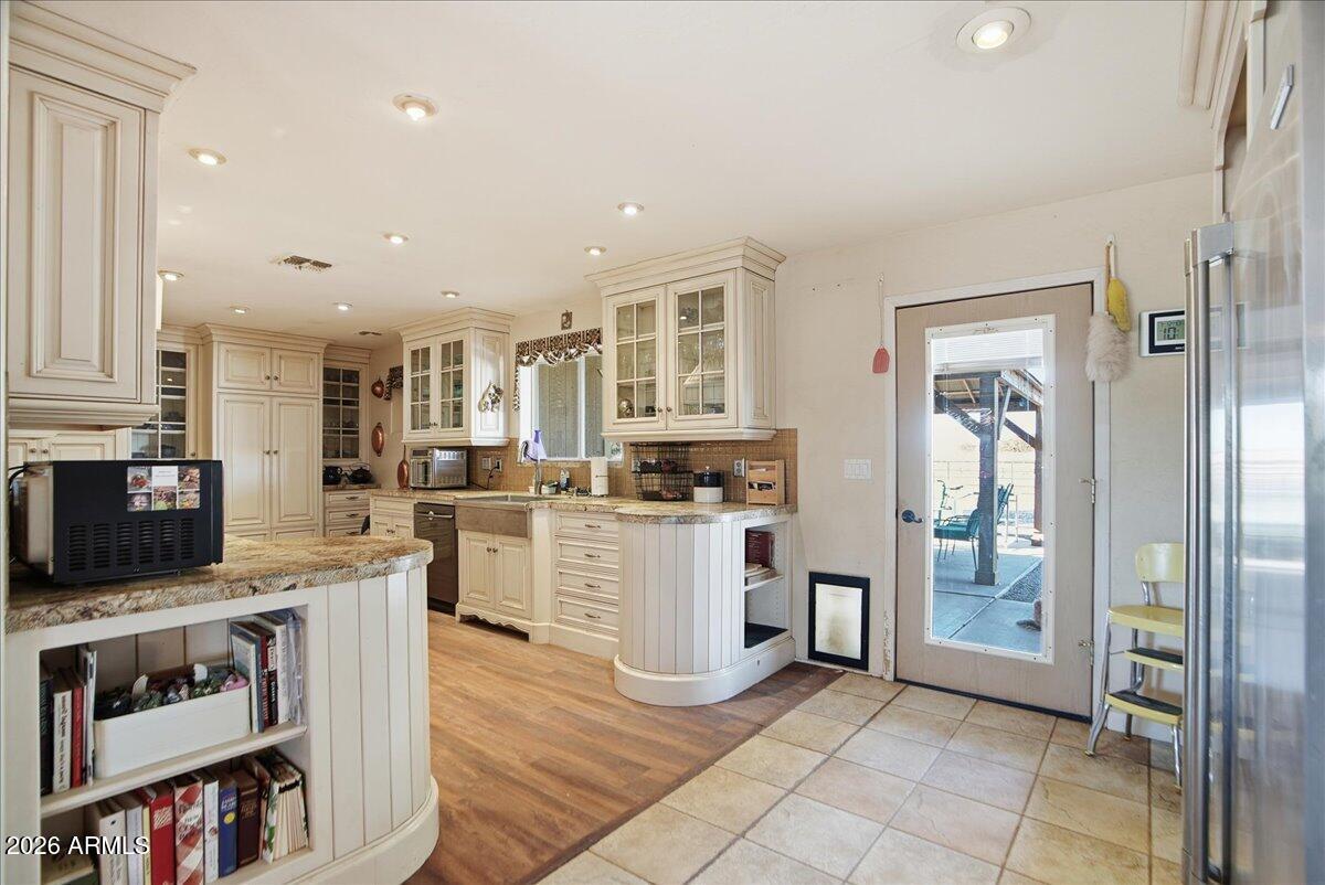 1414 West Ocotillo Road San Tan Valley, AZ 85140 - Photo 12 of 62 a kitchen with stainless steel appliances granite countertop a refrigerator oven a sink dishwasher and white cabinets with wooden floor