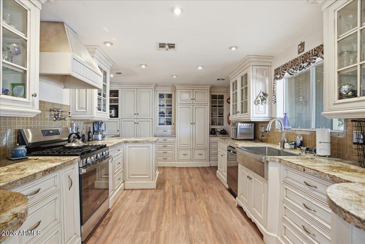 1414 West Ocotillo Road San Tan Valley, AZ 85140 - Photo 14 of 62 a large kitchen with stainless steel appliances granite countertop a lot of counter space and wooden floors