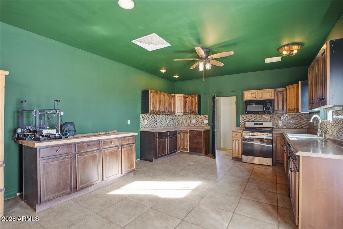 1414 West Ocotillo Road San Tan Valley, AZ 85140 - Photo 29 of 62 a kitchen with stainless steel appliances granite countertop a sink counter space cabinets and stainless steel appliances