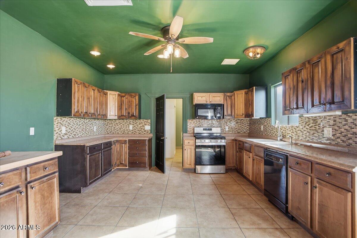 1414 West Ocotillo Road San Tan Valley, AZ 85140 - Photo 30 of 62 a kitchen with stainless steel appliances granite countertop a sink and cabinets