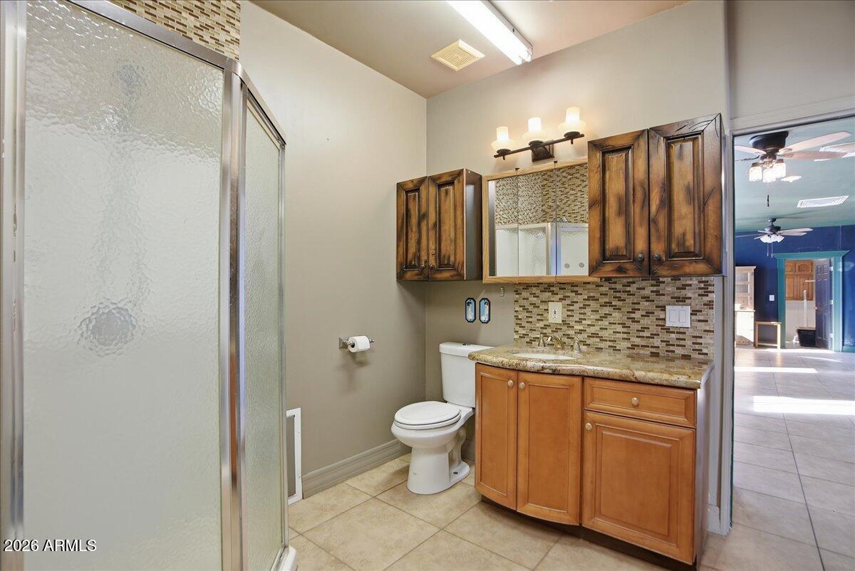 1414 West Ocotillo Road San Tan Valley, AZ 85140 - Photo 36 of 62 a bathroom with a granite countertop sink a toilet and a shower