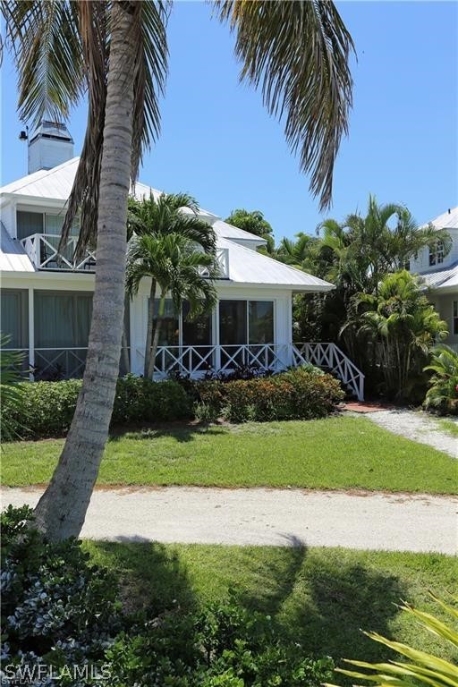 508 Useppa Island Bokeelia, FL 33922 - Photo 20 of 22 a front view of a house with a garden and palm trees