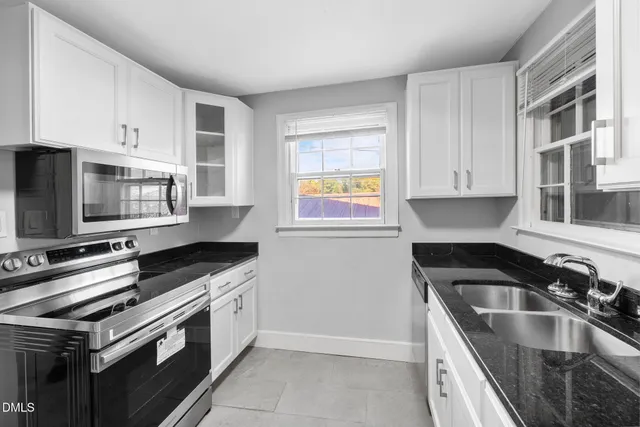 a kitchen with granite countertop a sink and steel appliances