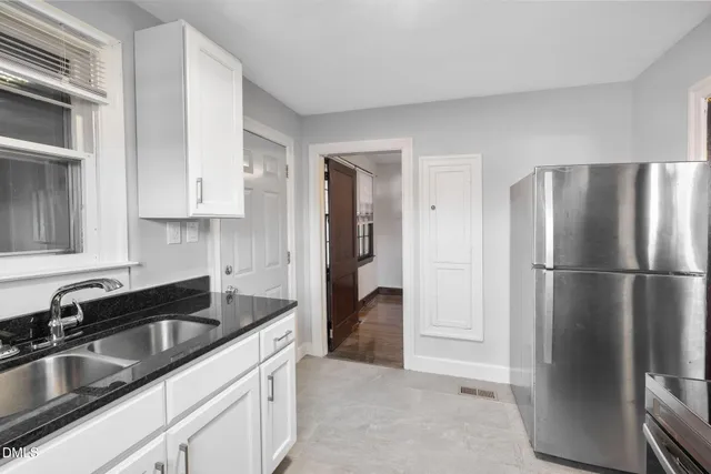 a kitchen with a refrigerator sink and cabinets