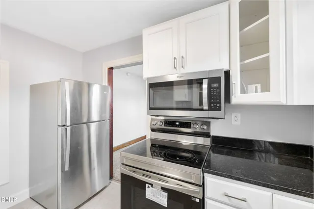a kitchen with white cabinets and stainless steel appliances