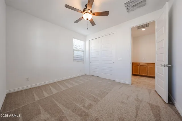 an empty room with fan and windows