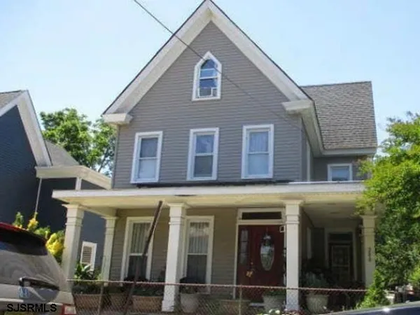 a front view of a house with glass windows and plants