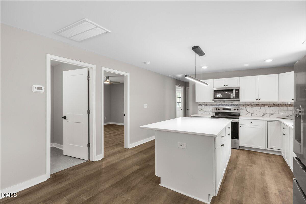 509 Sparella Street Durham, NC 27703 - Photo 13 of 30 a kitchen with white cabinets and stainless steel appliances