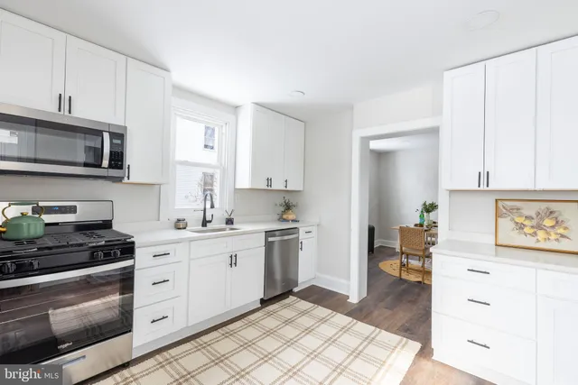 a kitchen with stainless steel appliances a stove sink and cabinets