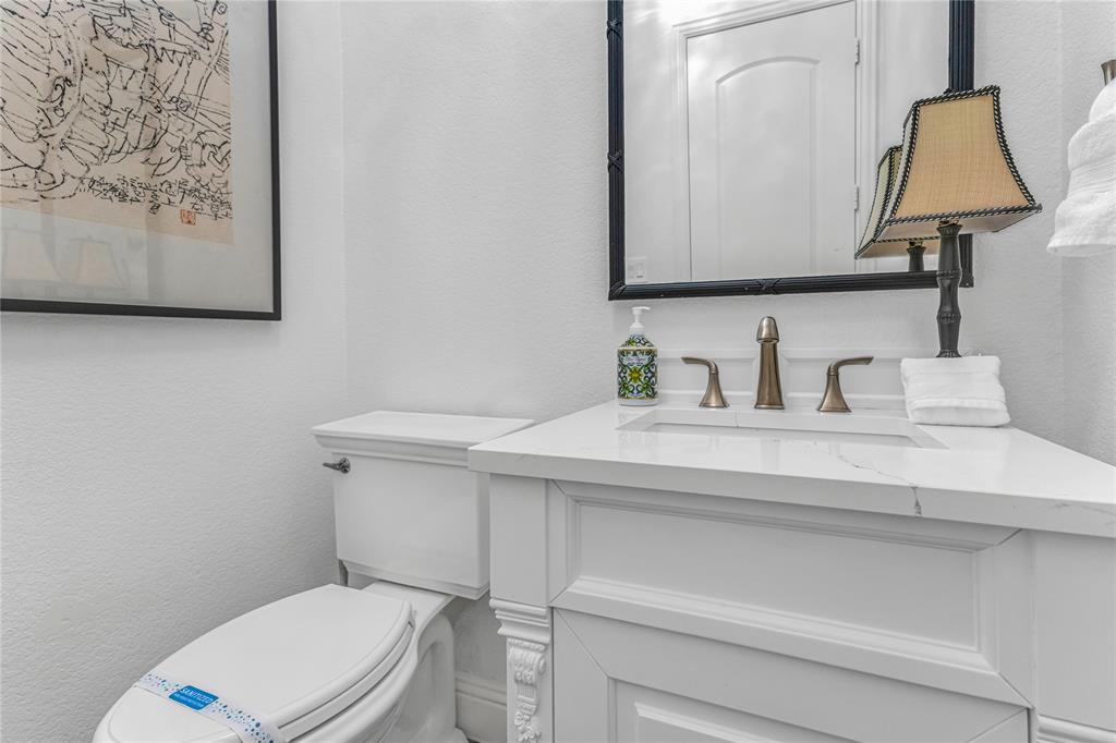 5744 Robbie Road Plano, TX 75024 - Photo 15 of 32 White vanity with a rectangular undermount sink, quartz countertop, and bronze-finish faucet