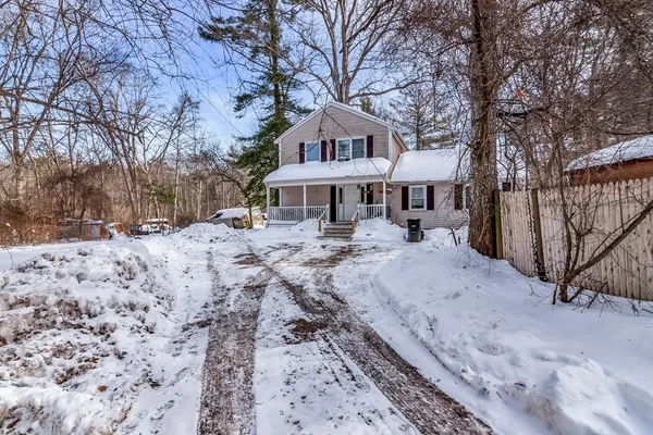 a front view of a house with a yard covered with snow