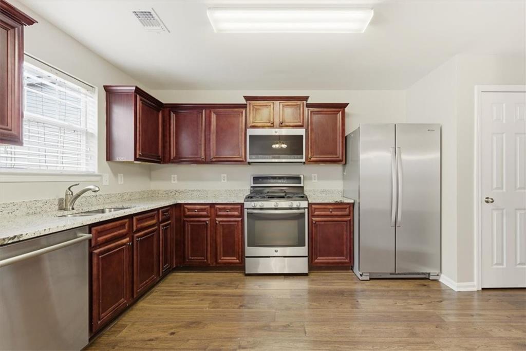 342 Hidden Creek Lane Canton, GA 30114 - Photo 16 of 30 a kitchen with stainless steel appliances granite countertop a stove top oven a sink and dishwasher