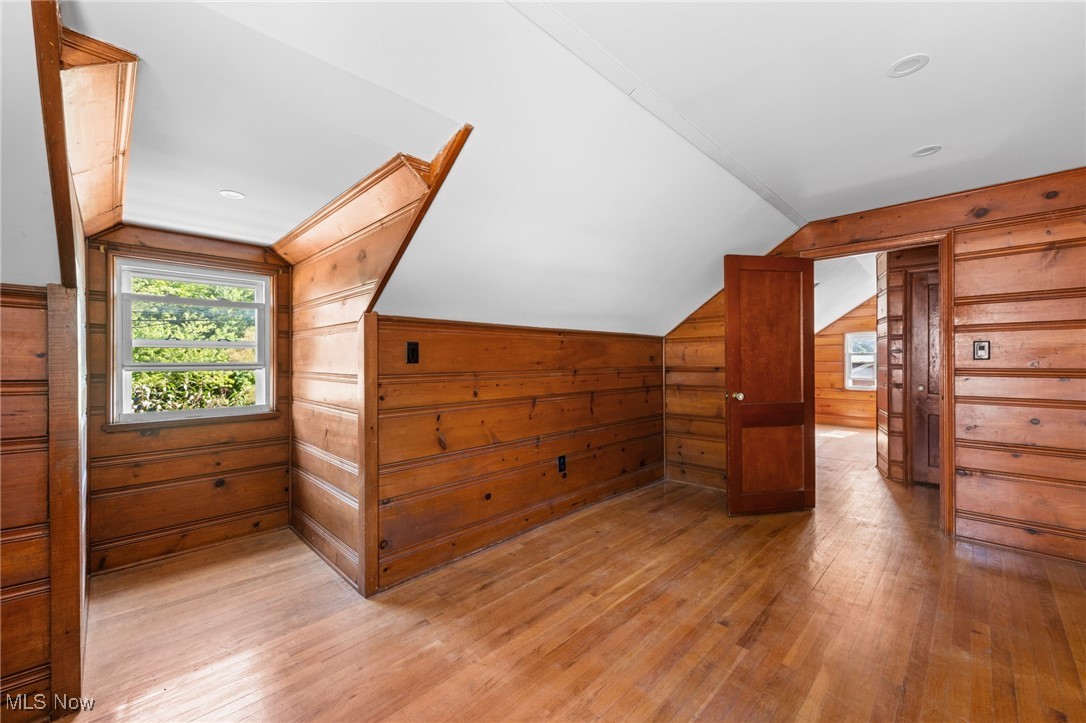 18122 Nottingham Road Cleveland, OH 44119 - Photo 17 of 29 Bedroom with wooden walls, light wood-style flooring, and lofted ceiling