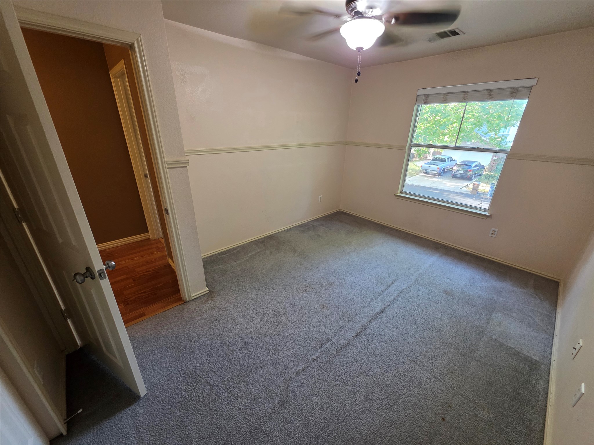2210 Wilma Rudolph Road Austin, TX 78748 - Photo 12 of 20 A windowed secondary bedroom features carpet flooring and a chair rail detailing the walls.