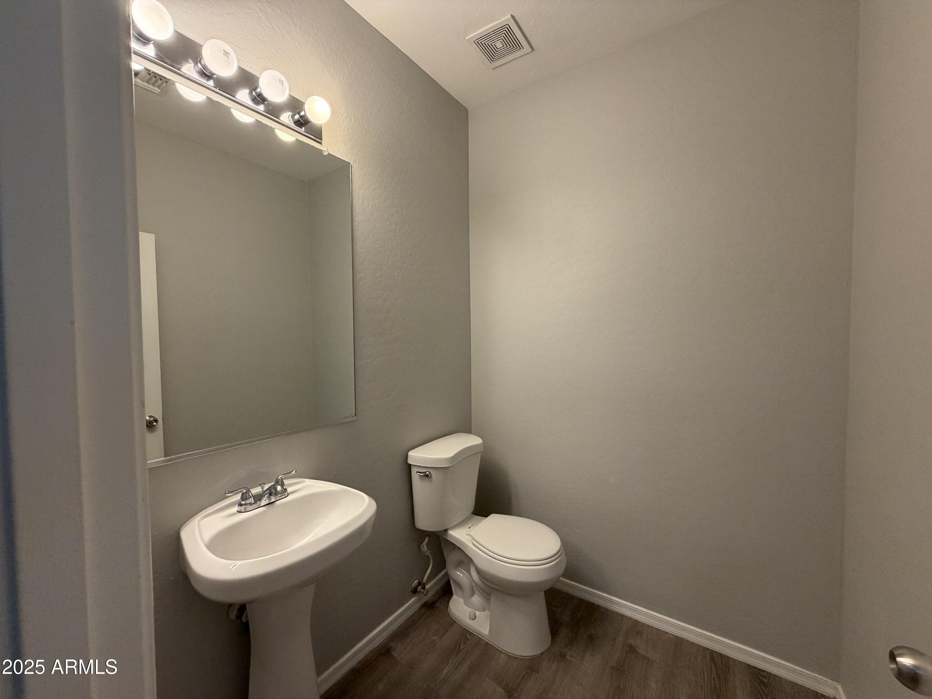18123 North Madison Road Maricopa, AZ 85139 - Photo 17 of 26 a bathroom with a toilet sink and mirror