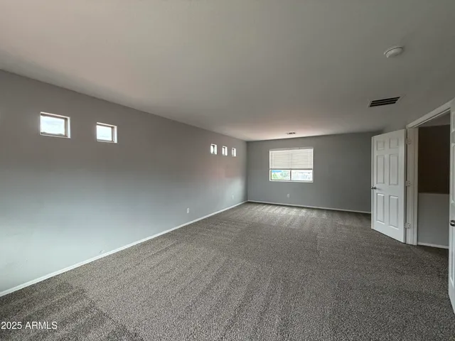 a view of an empty room with a window and a fireplace