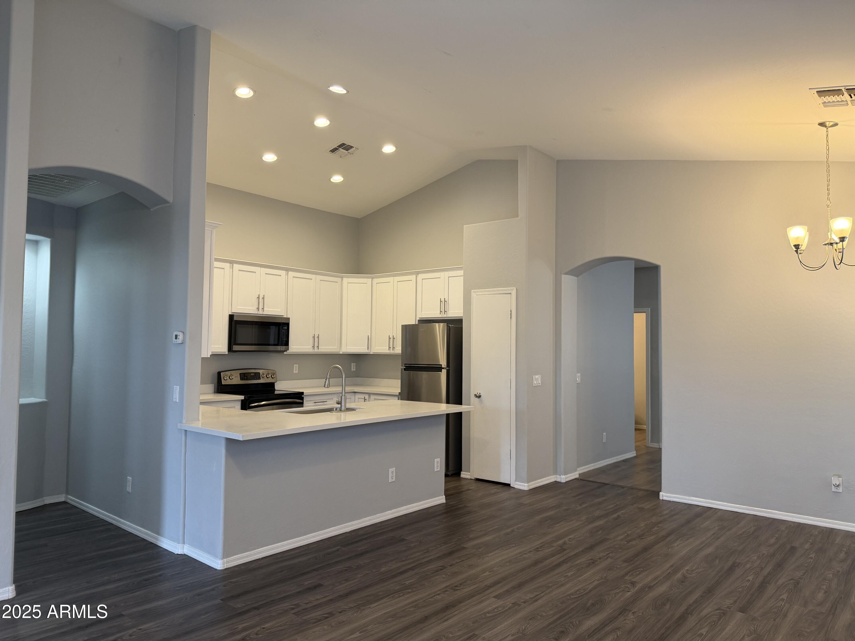 18123 North Madison Road Maricopa, AZ 85139 - Photo 3 of 26 a kitchen with a refrigerator and a stove top oven