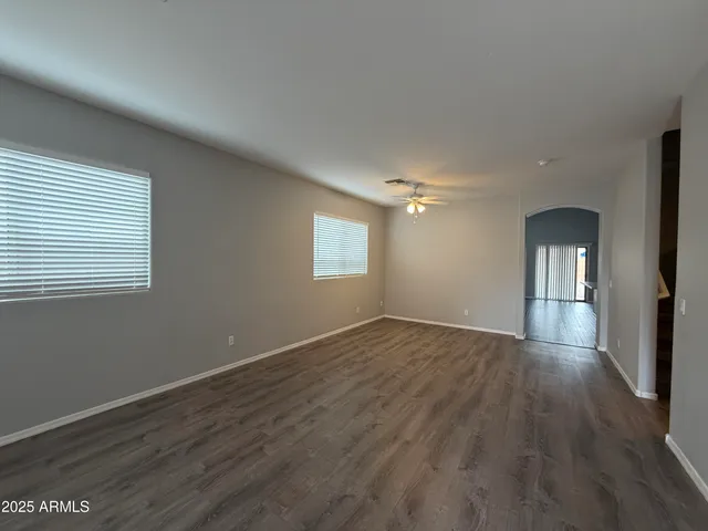 a view of empty room with window and wooden floor