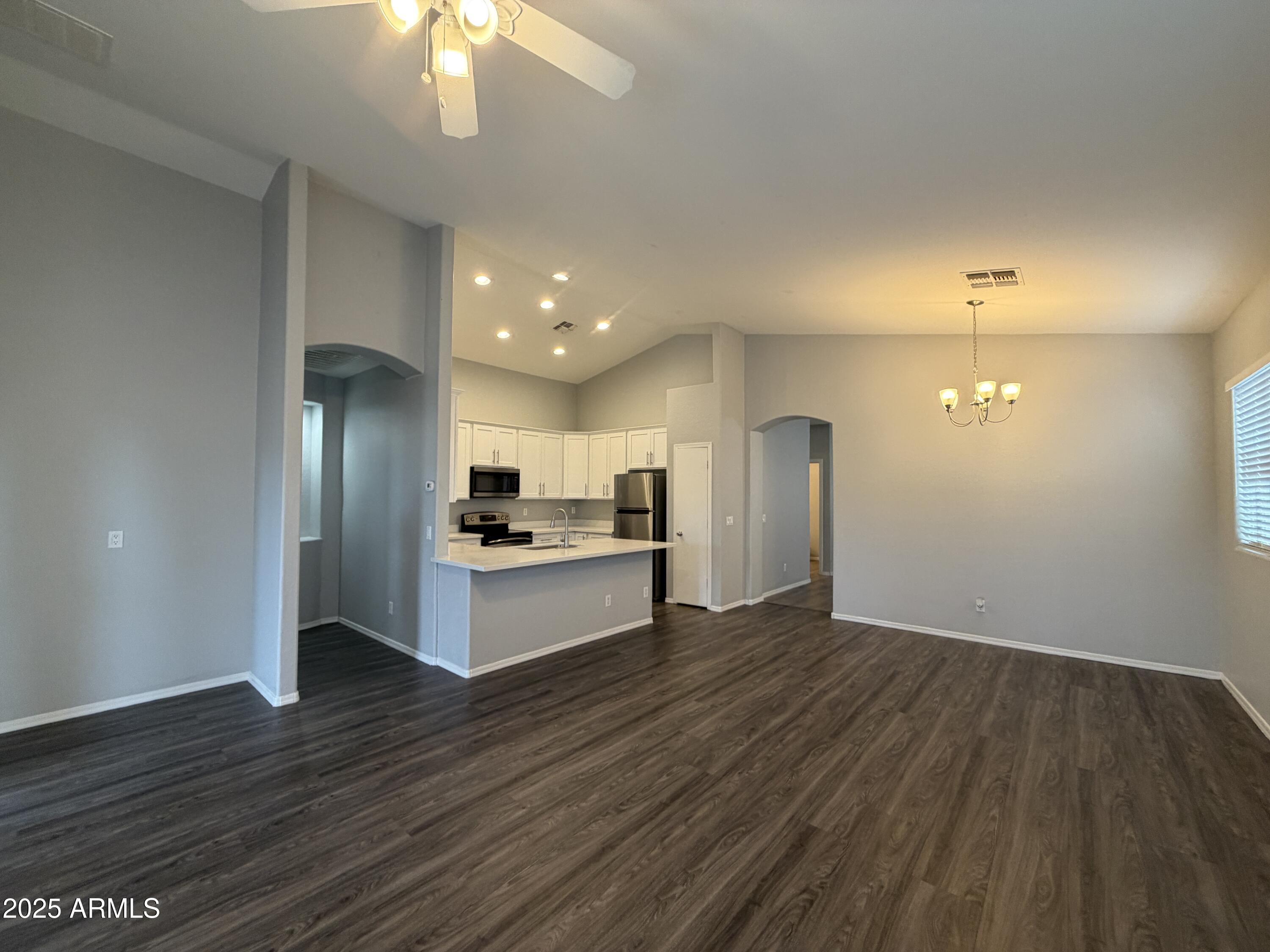 18123 North Madison Road Maricopa, AZ 85139 - Photo 5 of 26 a view of a kitchen with a sink and dishwasher a refrigerator with wooden floor