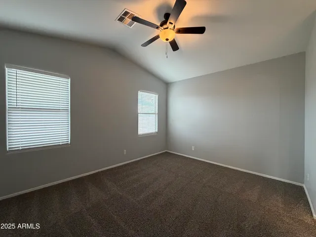 an empty room with a window and a fan