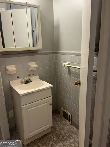 an empty room with wooden floor and fan