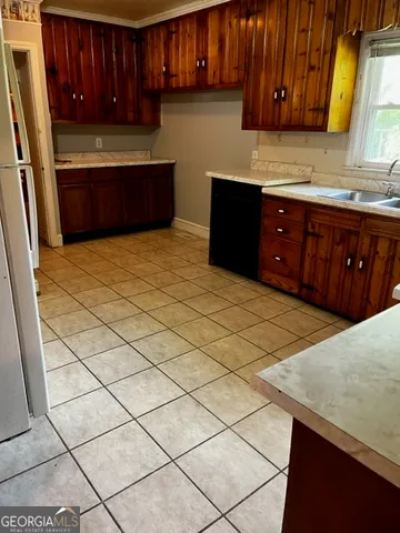 a kitchen with stainless steel appliances a sink a stove a microwave a sink and cabinets