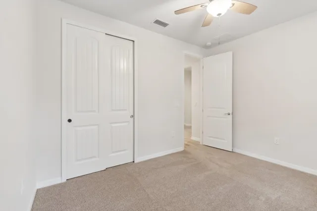 a large kitchen with kitchen island white cabinets and stainless steel appliances