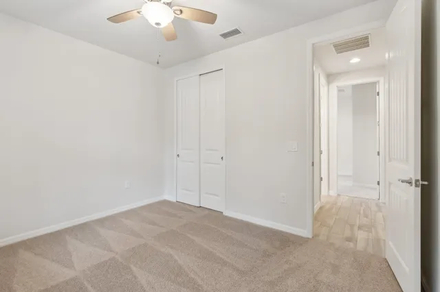 an empty room with a chandelier fan