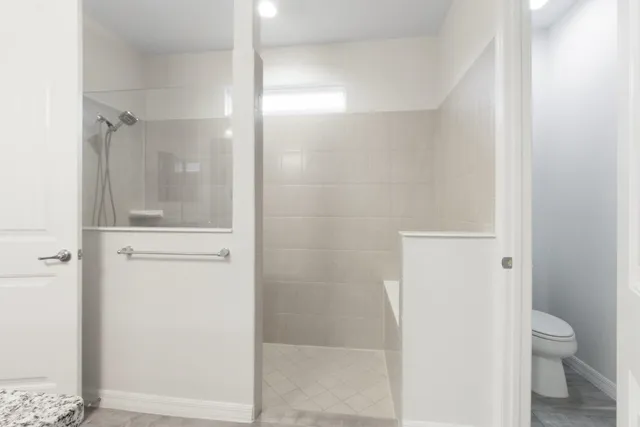 a bathroom with a granite countertop toilet and a shower