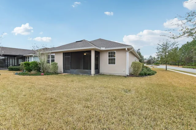 a front view of house with yard and trees in the background