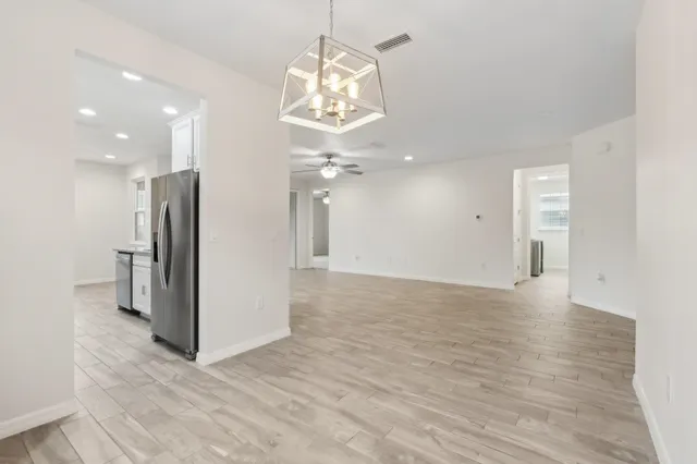 wooden floor in an empty room with a kitchen