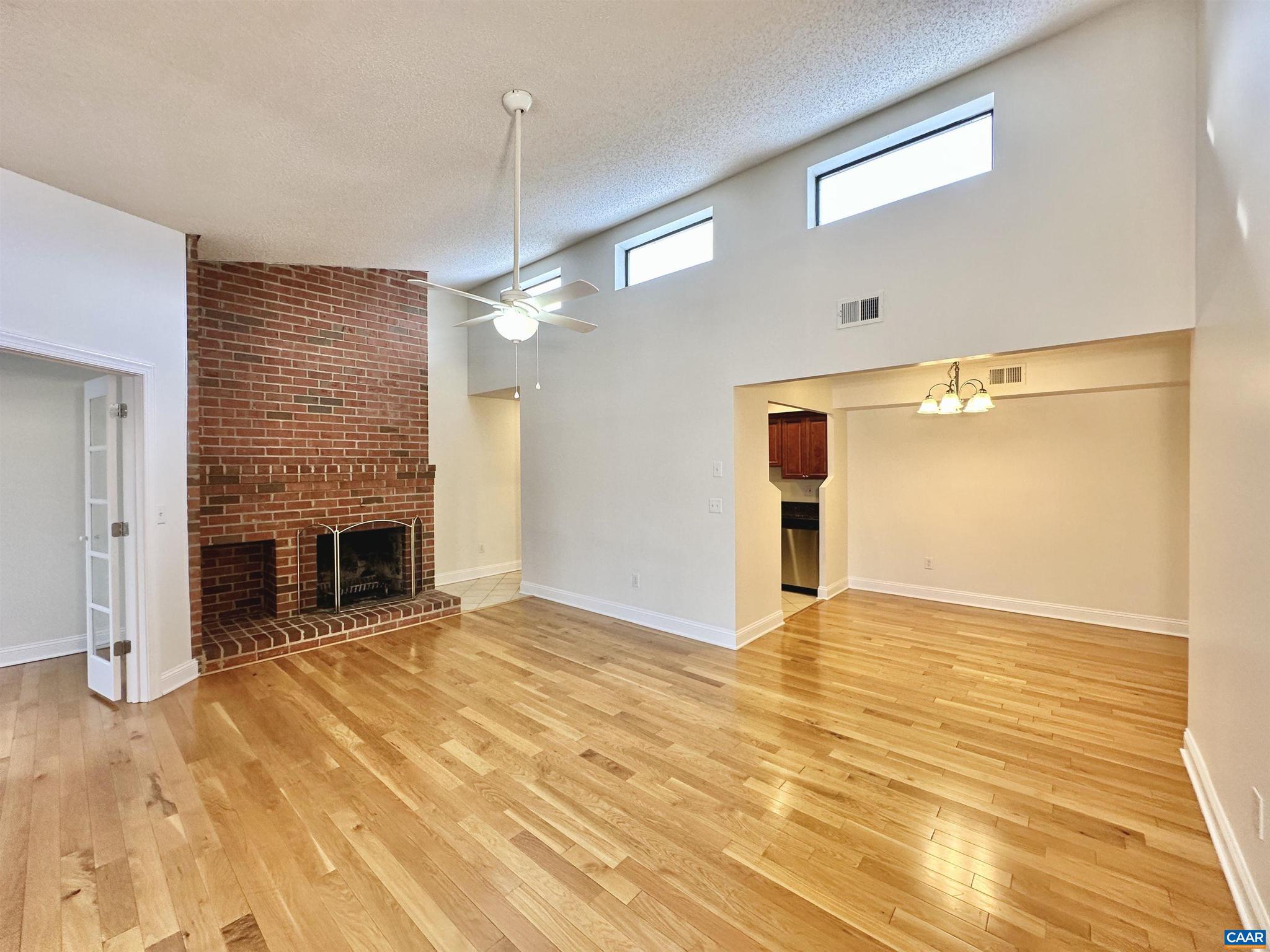 a view of an empty room with a fireplace and a window