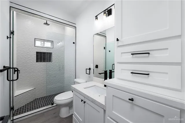 a bathroom with a sink a toilet and shower