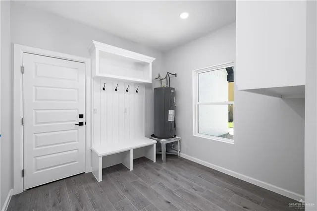 an empty room with wooden floor closet and windows