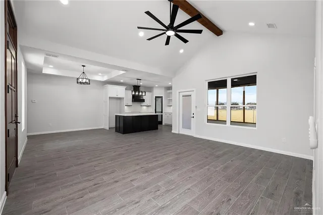 a large white kitchen with a large kitchen island white cabinetry and stainless steel appliances