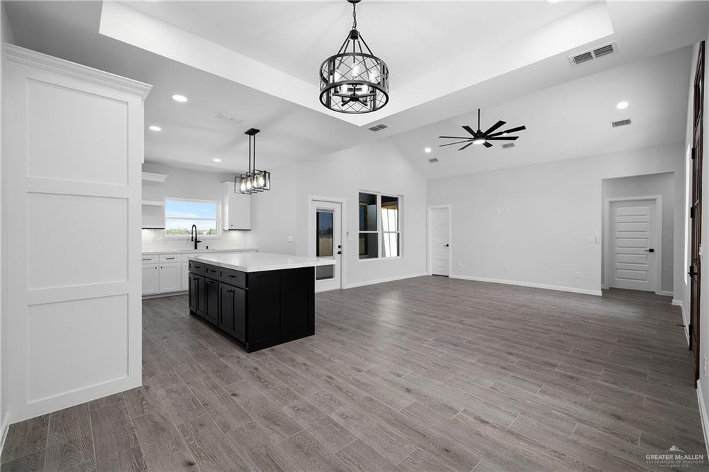 2443 Lady Palm Drive Rio Grande City, TX 78582 - Photo 19 of 19 a large white kitchen with a large kitchen island white cabinetry and stainless steel appliances