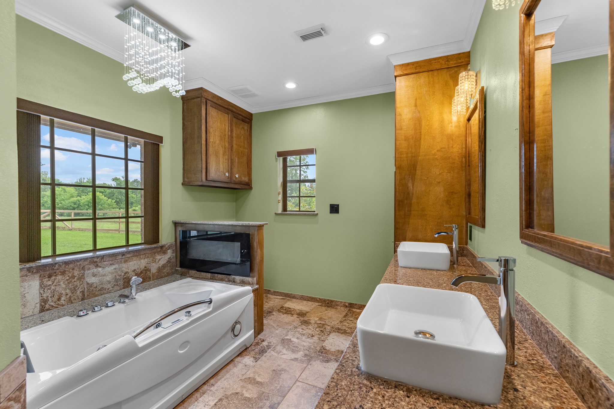 17126 County Road 39 Rosharon, TX 77583 - Photo 12 of 47 Separate sinks and mirrors with custom crafted solid wood cabinets with hidden soft close hinges and lots of soft close drawers. The tub is amazing with uv cleaning, led lighting, jets with inline heating and neck rest. LED fireplace has several settings and can heat or just add to visual ambiance.
