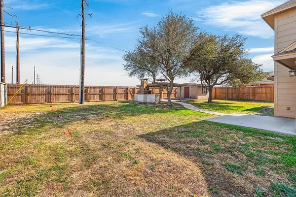 a view of a swimming pool with a yard and a large tree