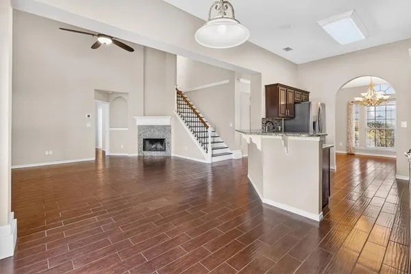 a view of a room with wooden floor fireplace and windows