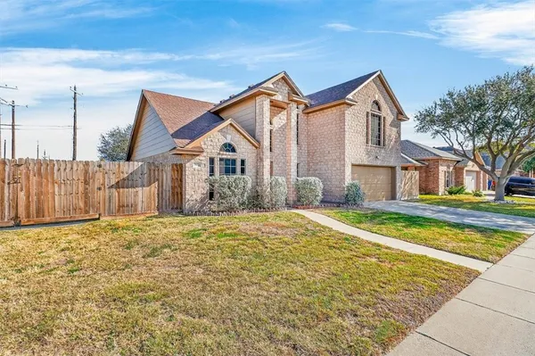 a view of a white house with a small yard and wooden fence
