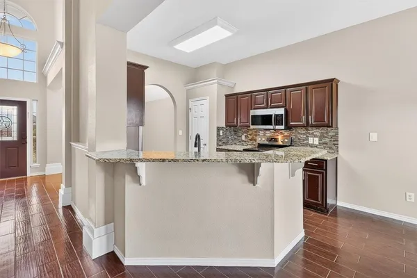 a kitchen with stainless steel appliances granite countertop a refrigerator microwave and stove