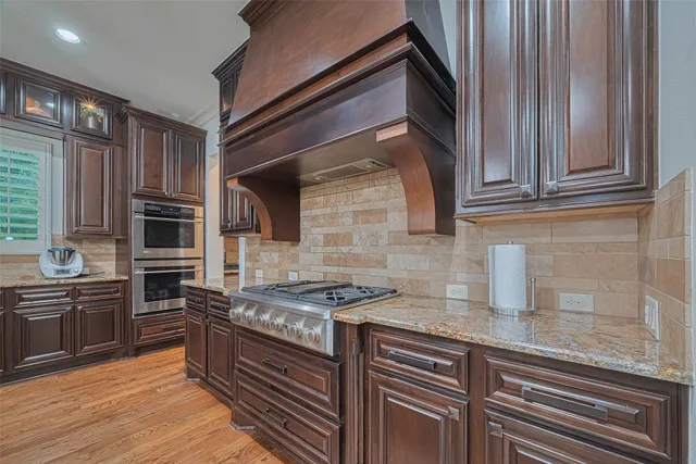 a kitchen with granite countertop stainless steel appliances and wooden cabinets